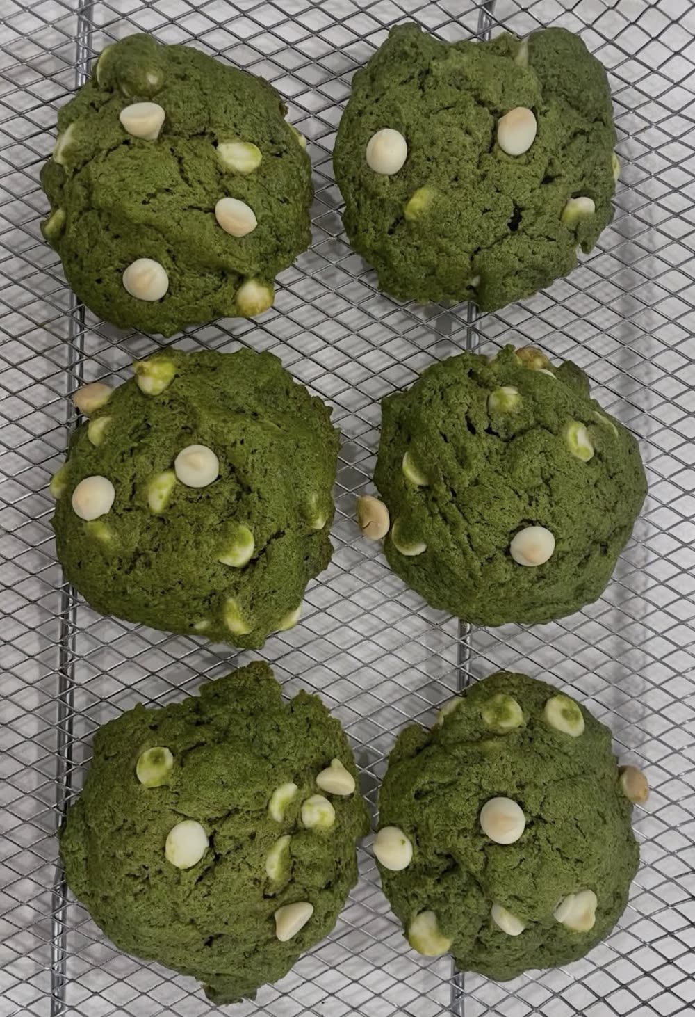 Matcha white chocolate chip cookies cooling on a rack