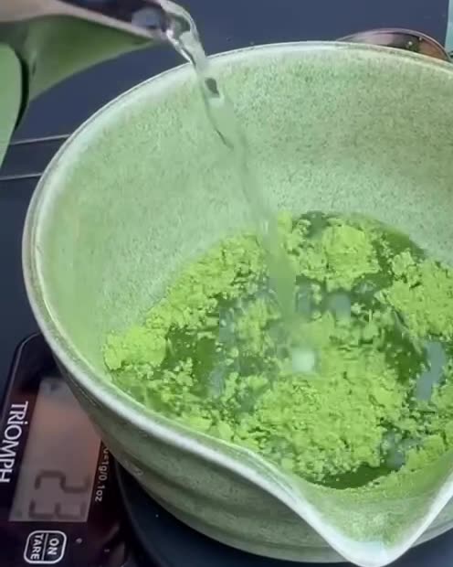 Matcha being whisked in a ceramic bowl